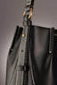 A sleek crossbody bag in muted gold, photographed with gentle natural light highlighting its fine texture.