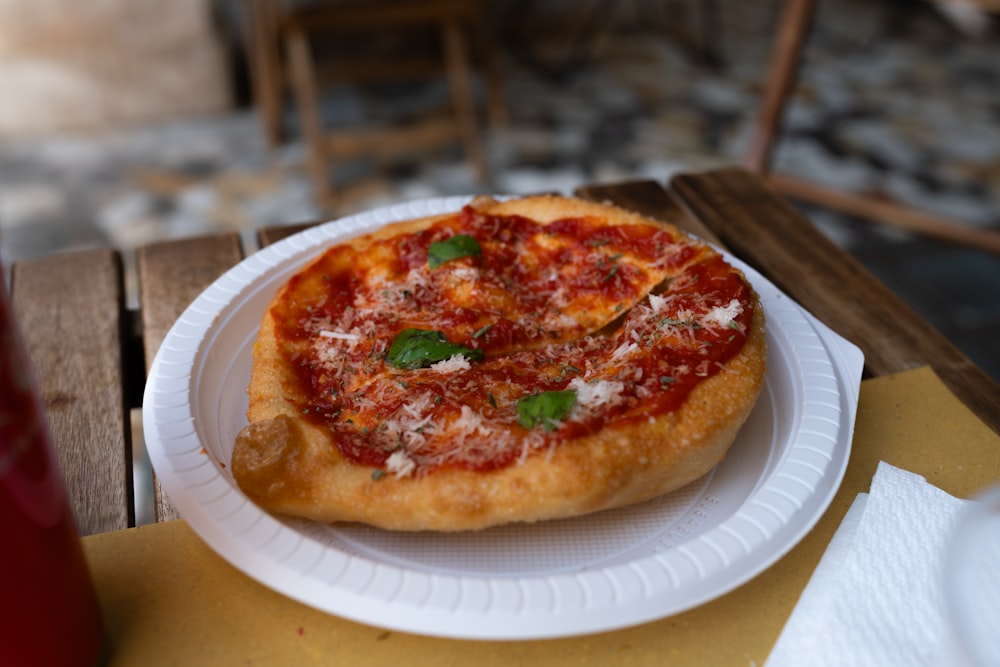 a small pizza on a paper plate on a table