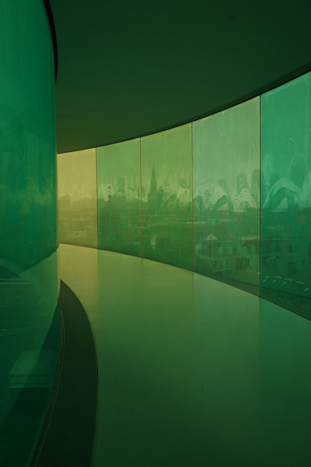 a curved room with a green glass wall