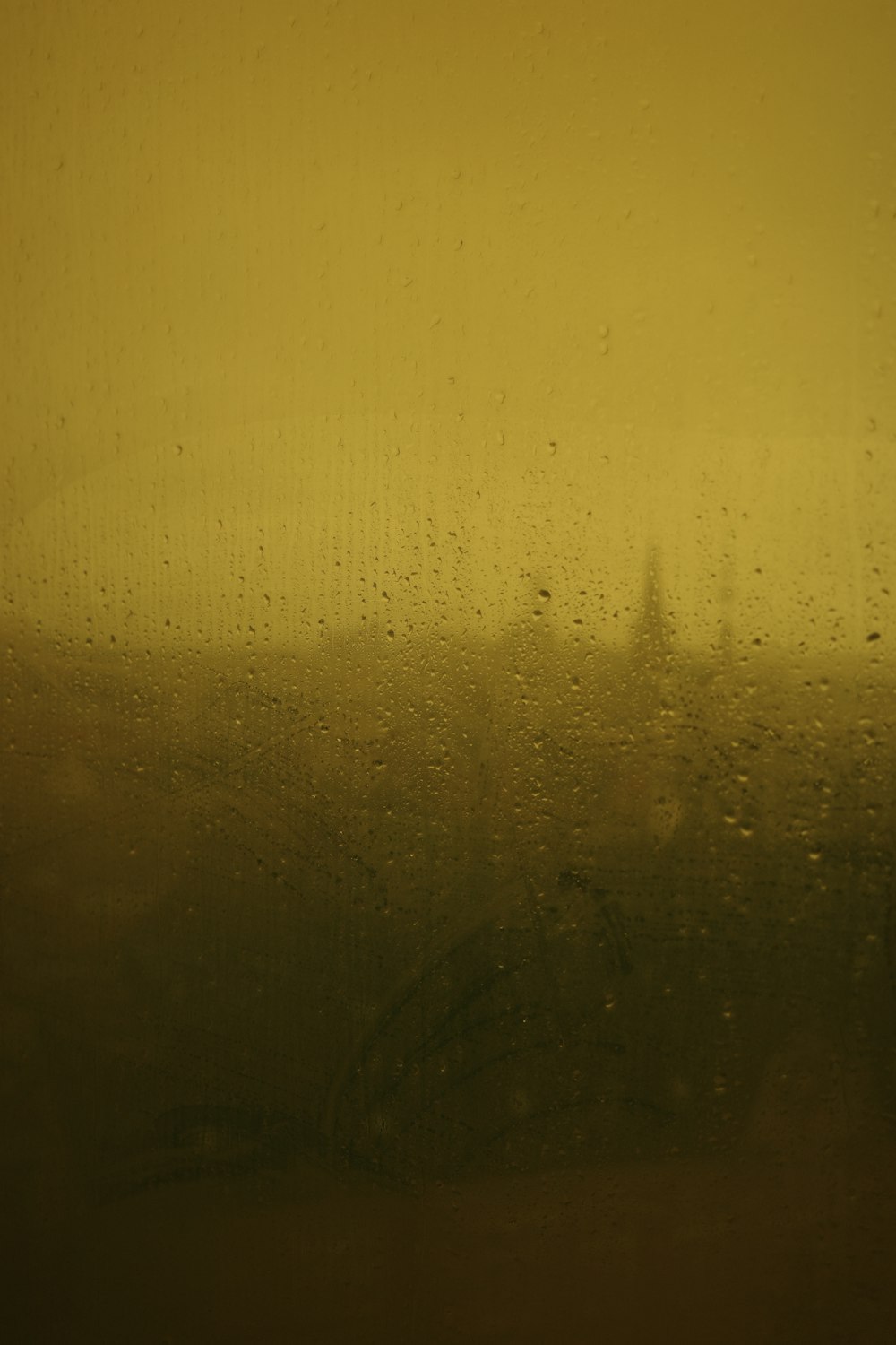 Una vista de un edificio a través de una ventana cubierta de lluvia