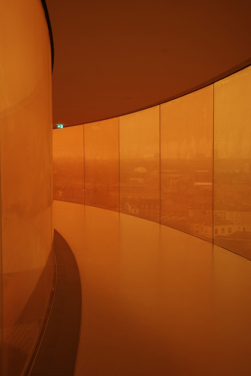 a curved wall with a view of a city in the distance