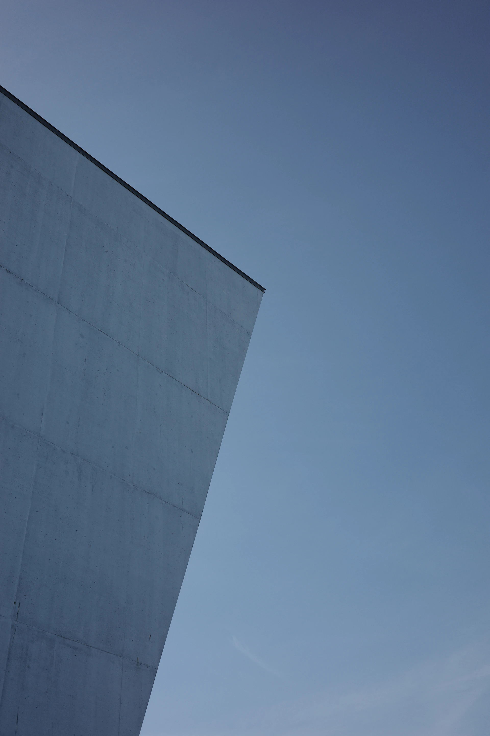 a plane flying in the sky over a building