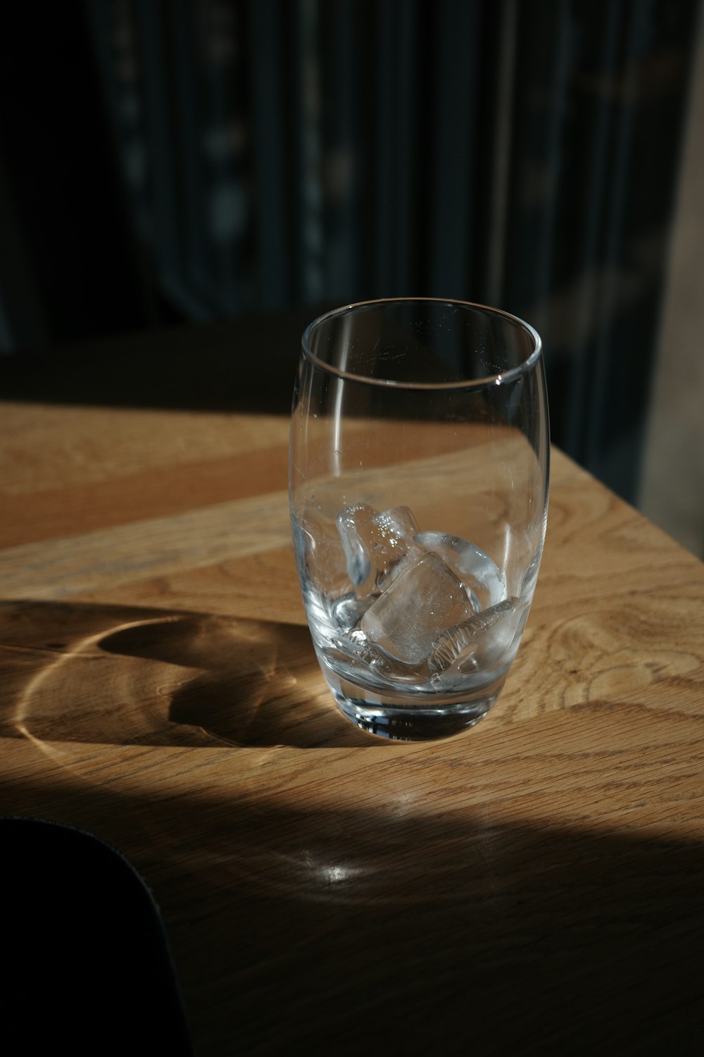 a glass of water sitting on top of a wooden table