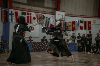 Close-up of a kendo sword striking a target during a lively competition.