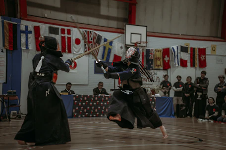 Close-up of a kendo sword striking a target during a lively competition.