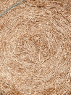 Close-up of compressed hay pellets neatly stacked in a rustic basket.