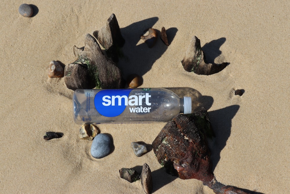 a smart water bottle laying on the sand