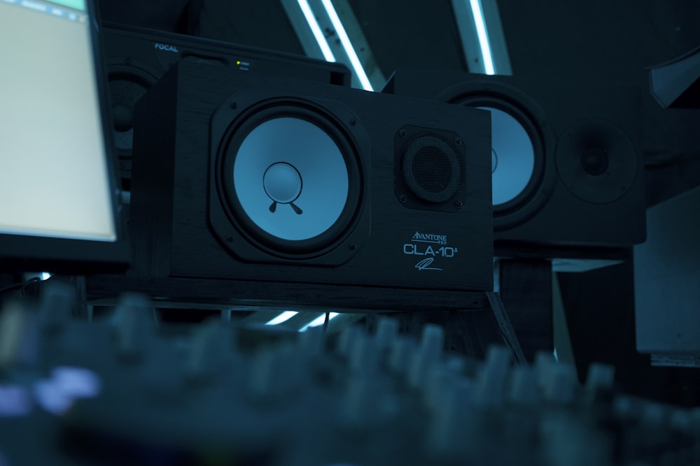 a close up of a speaker with a monitor in the background