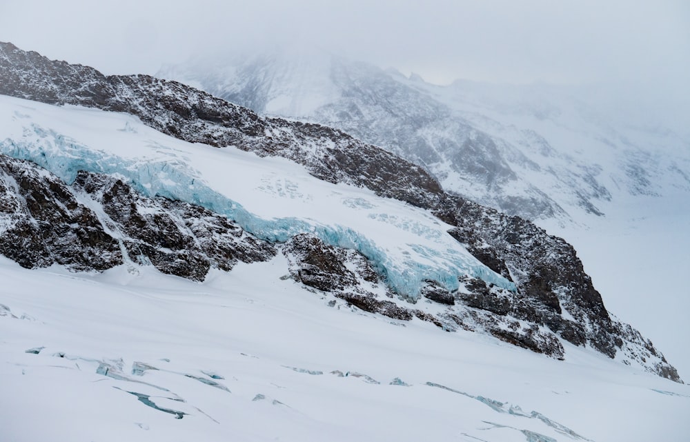 a mountain covered in snow and ice on a cloudy day