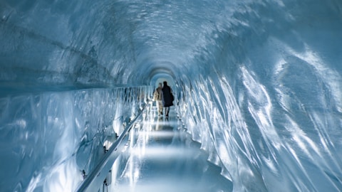 a man is walking through a tunnel of ice