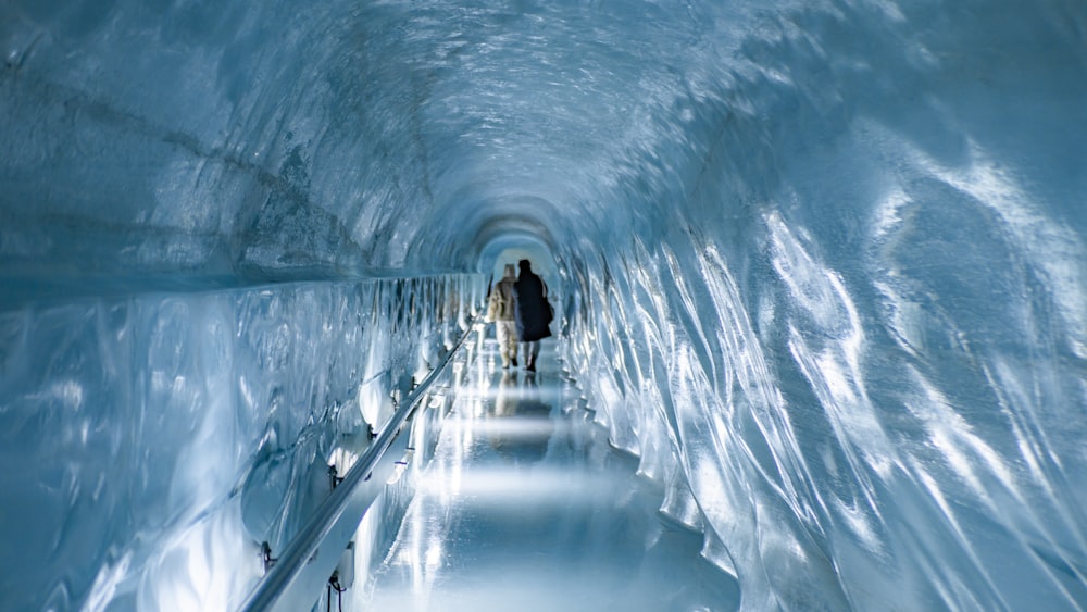 a man is walking through a tunnel of ice