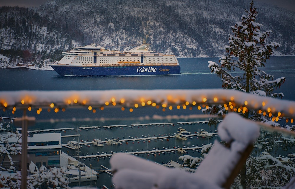 a cruise ship in the water near a snowy mountain
