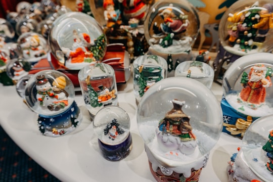 A collection of tumblers featuring holiday and seasonal decorations displayed on a rustic wooden table.