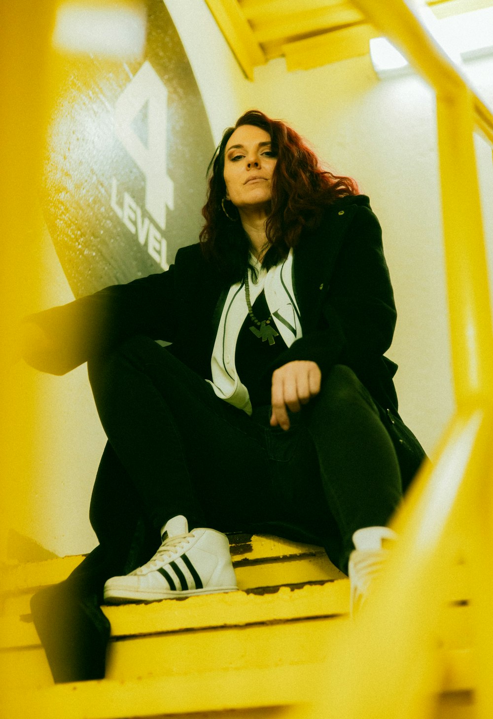 a woman is sitting on a yellow bench