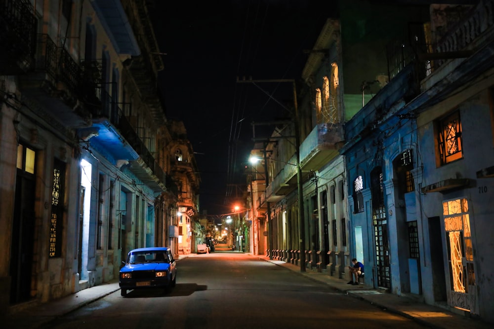 a car parked on the side of a street at night