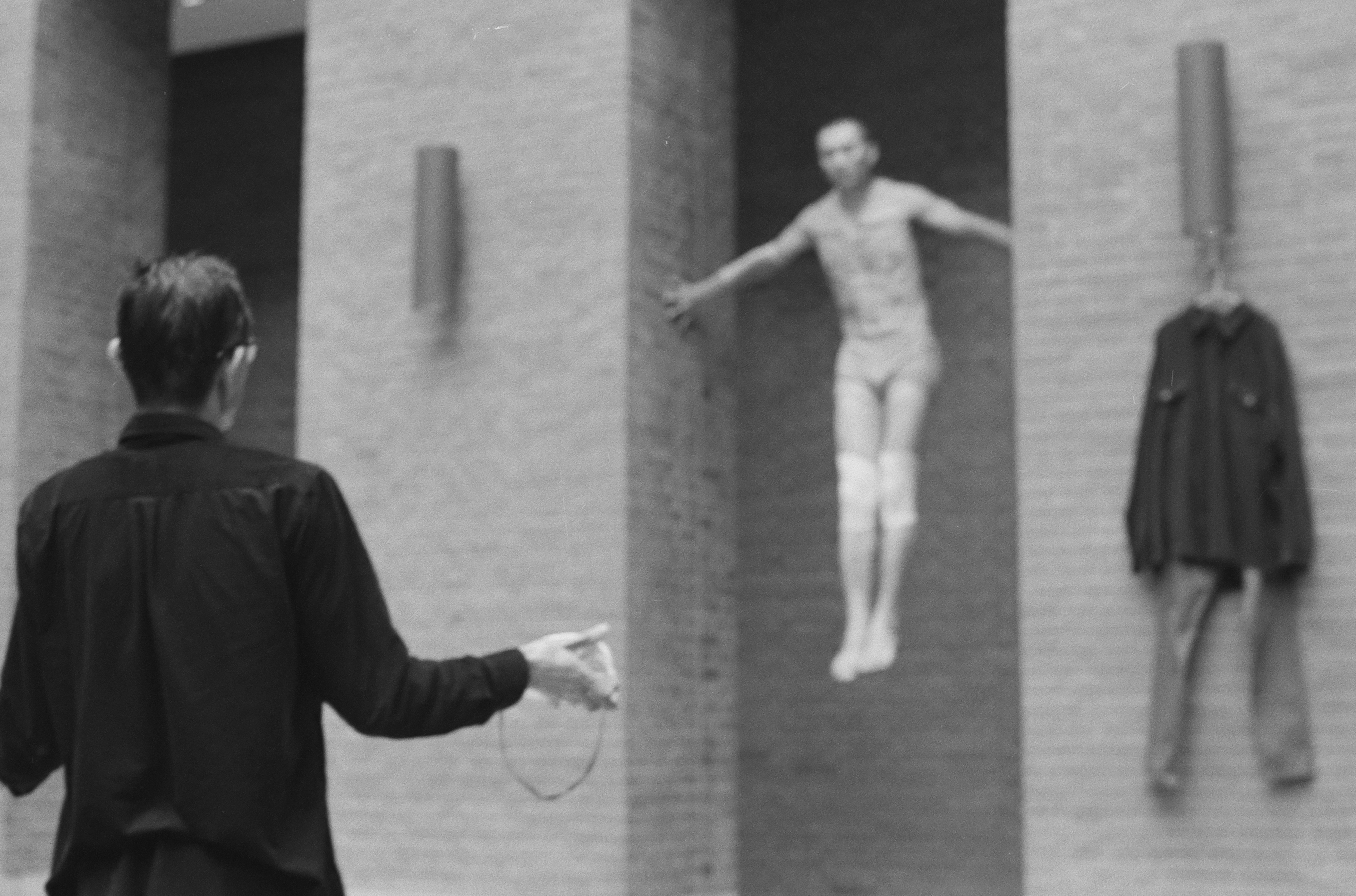 ein Schwarz-Weiß-Foto eines Mannes, der vor einer Statue eines