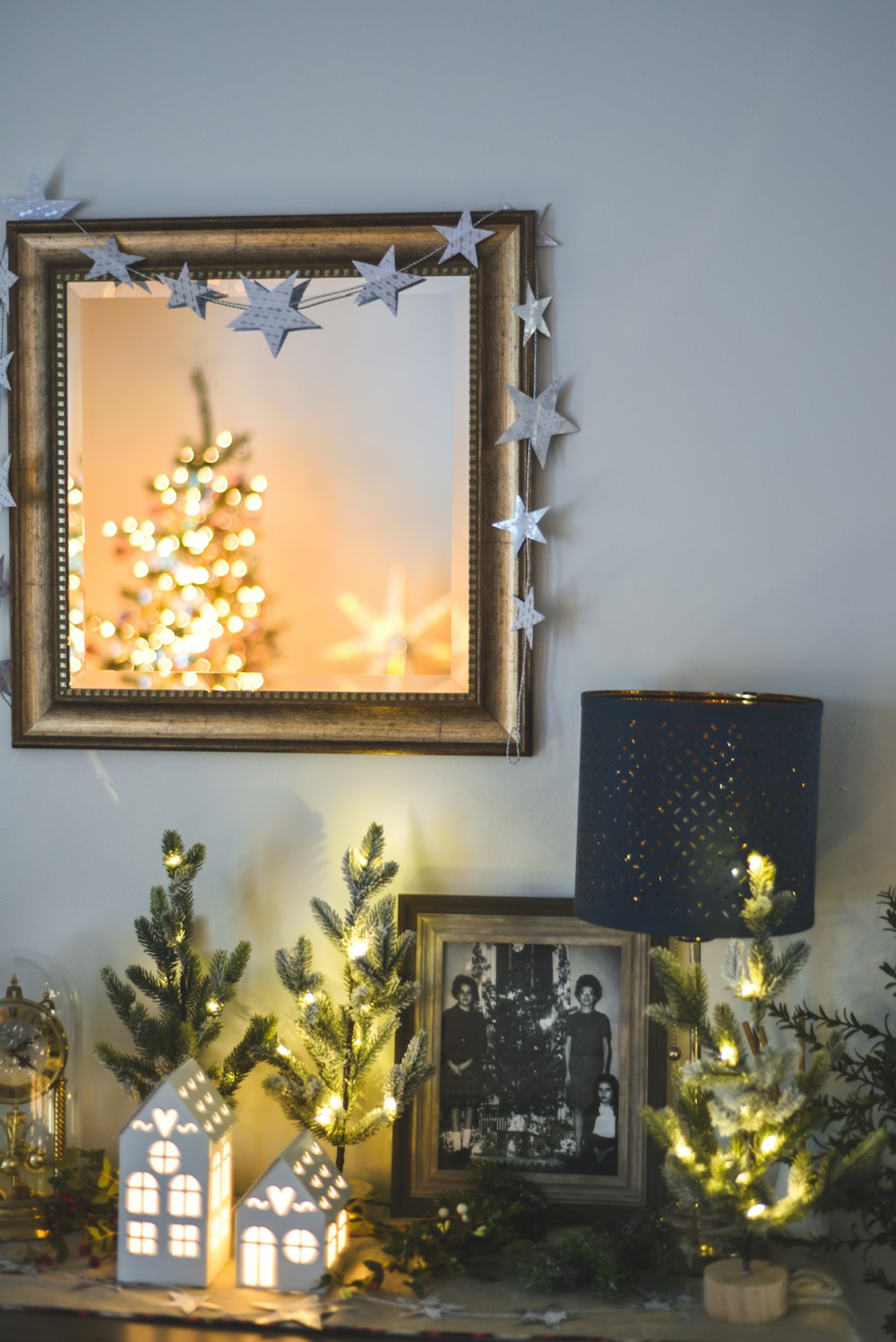 a mantle with a christmas tree and other decorations