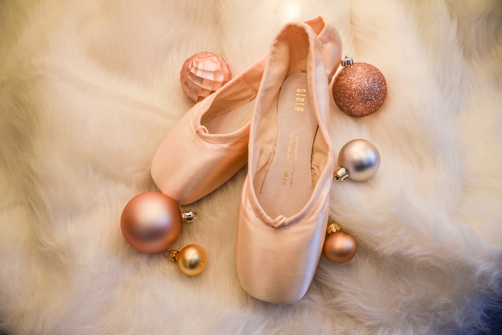 a pair of ballet shoes and ornaments on a fur rug