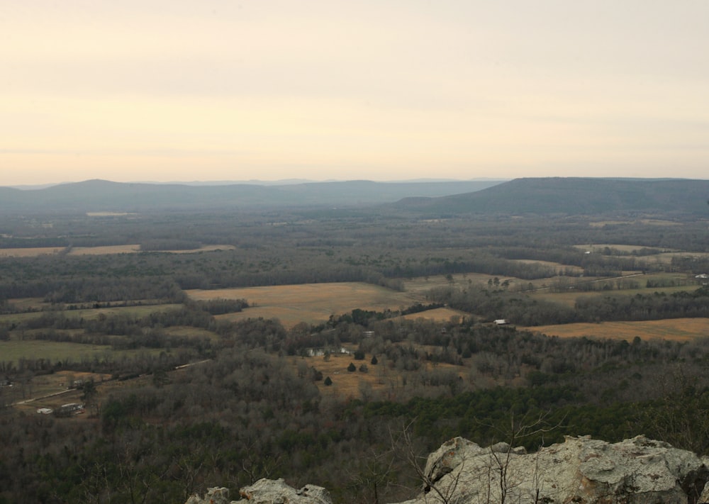 a person sitting on top of a mountain overlooking a valley