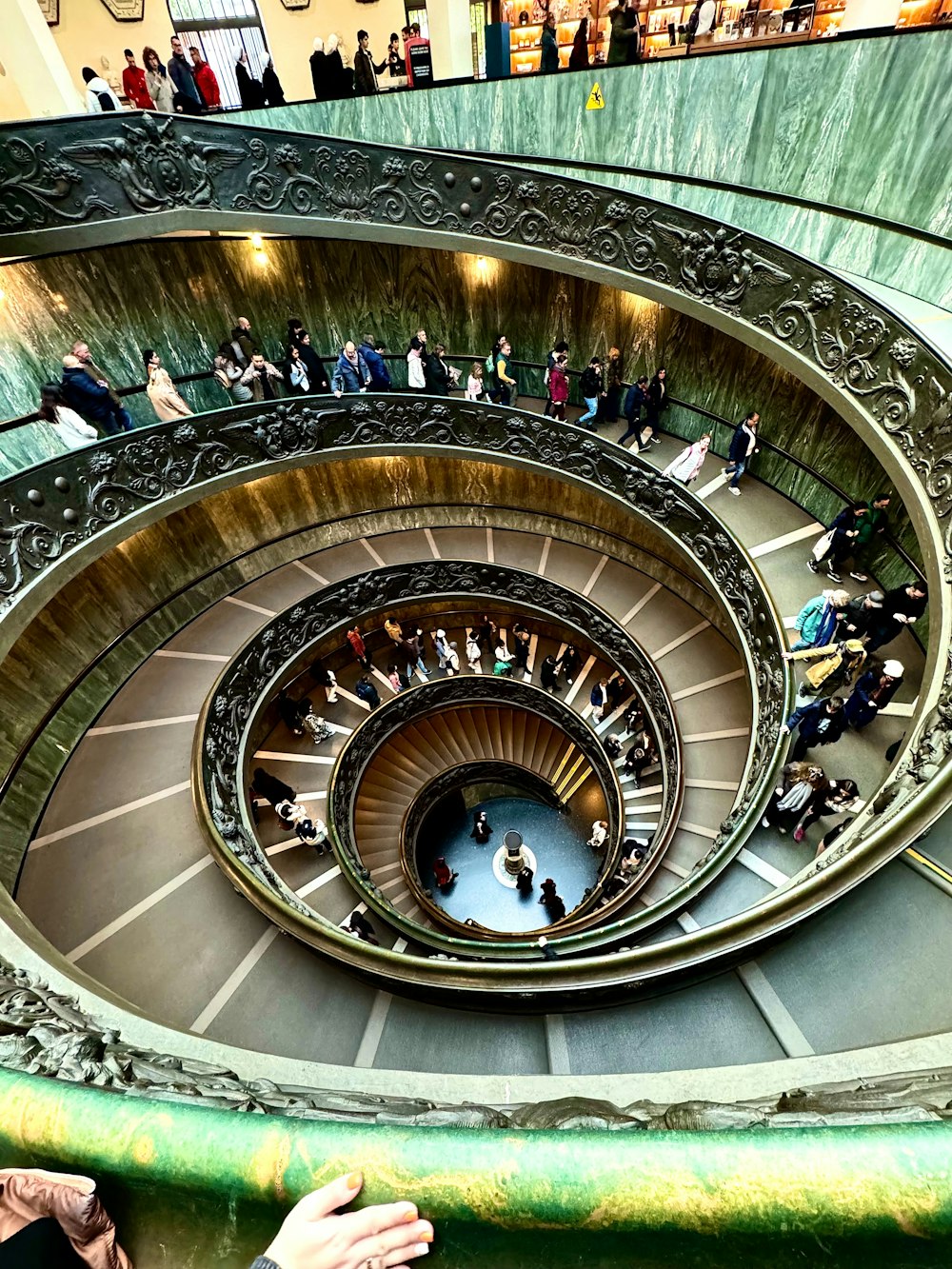Un grupo de personas de pie en lo alto de una escalera de caracol