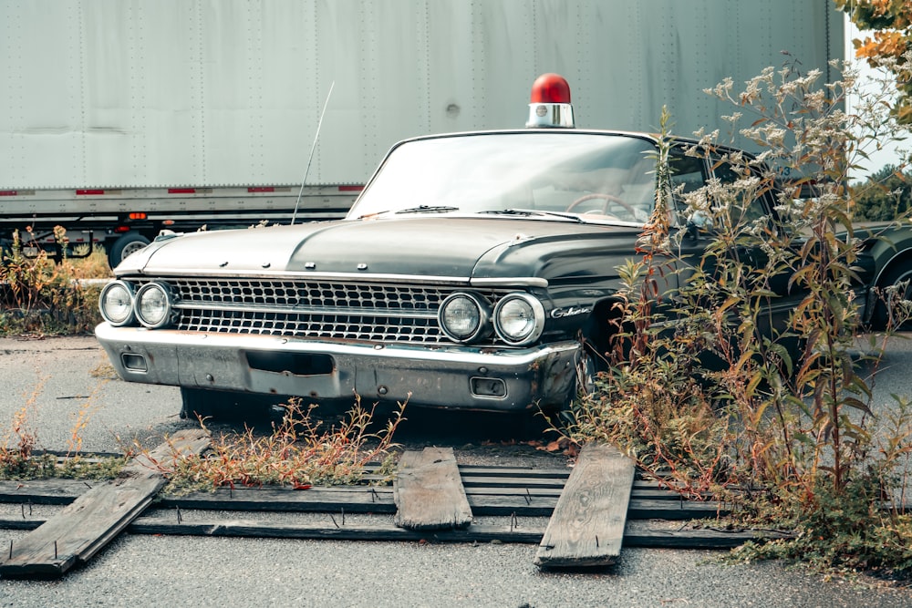 an old police car sitting on a train track