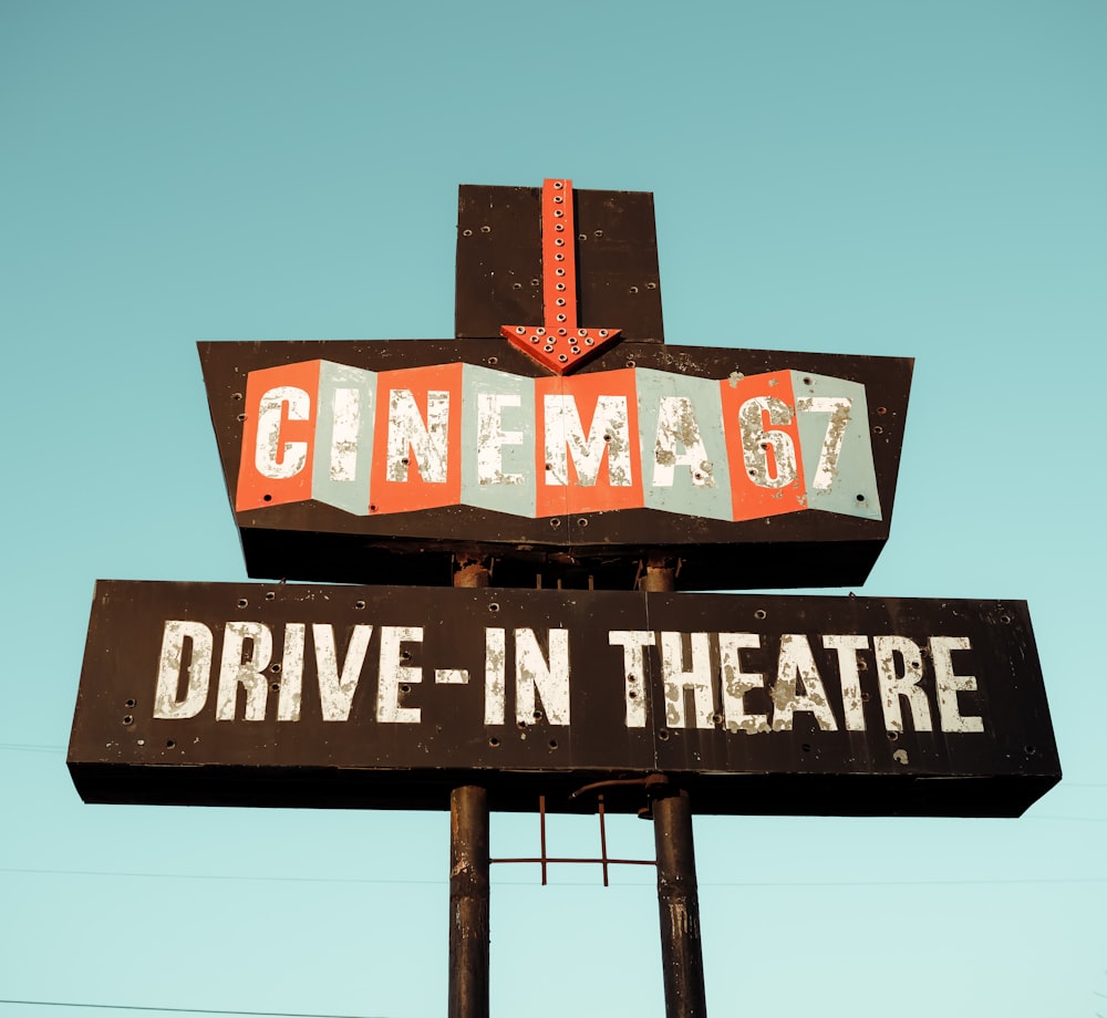 a sign for a drive - in theatre with a sky background