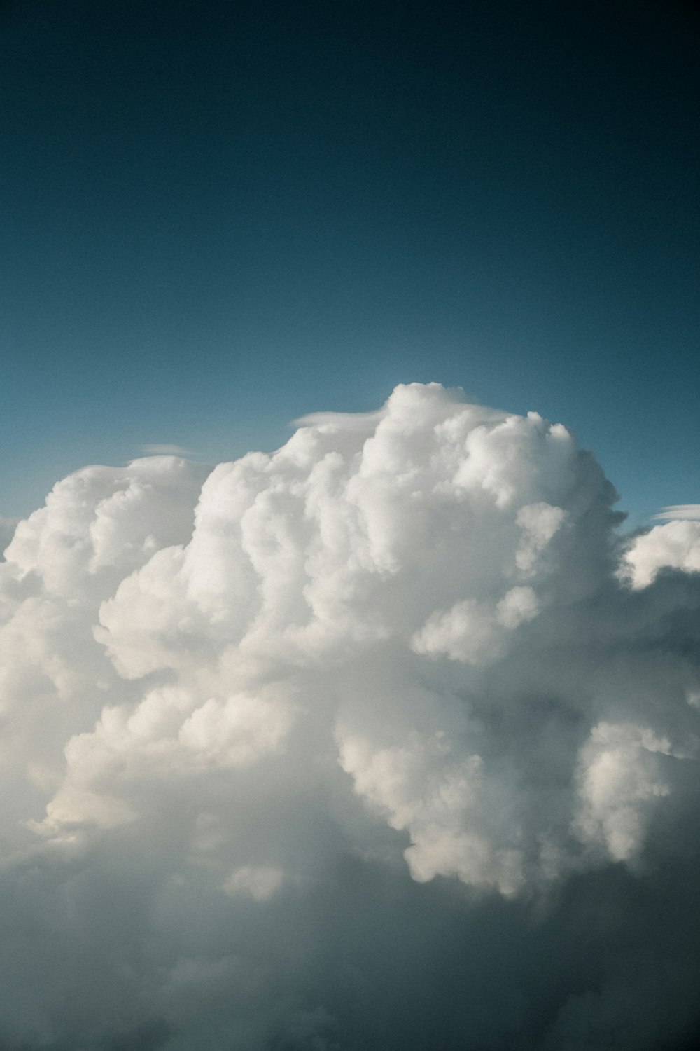 a plane flying through a cloud filled sky