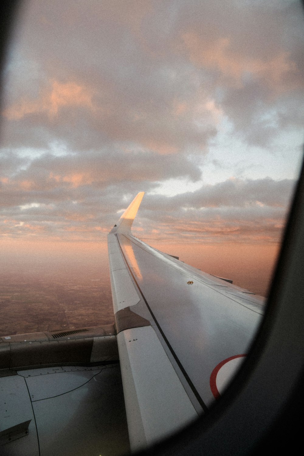 Blick auf den Flügel eines Flugzeugs, wie es am Himmel fliegt