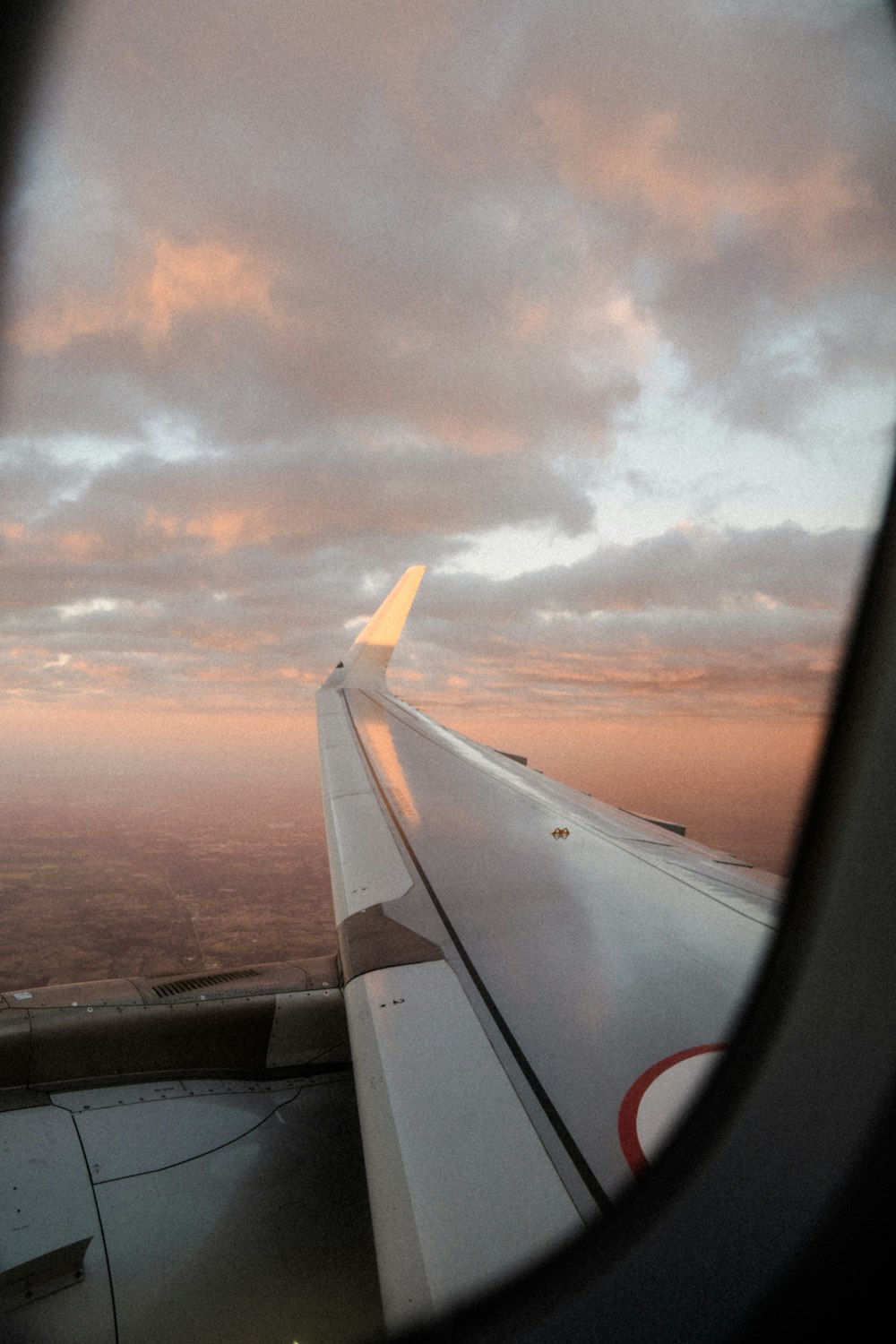 a view of the wing of an airplane as it flies in the sky