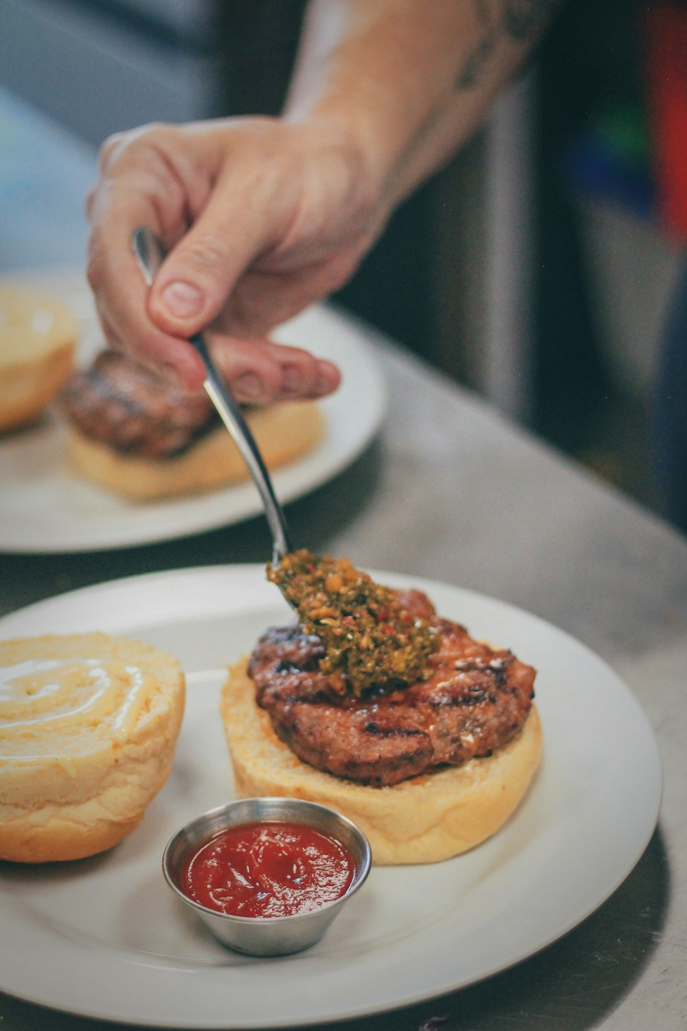 a person cutting into a hamburger on a plate