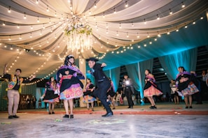A lively dance floor scene with guests celebrating joyfully at a multicultural wedding reception