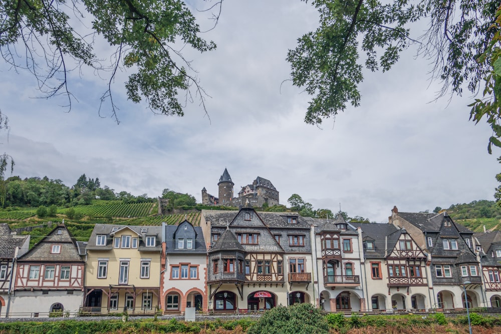 uma fileira de casas multi - coloridas com um castelo no fundo