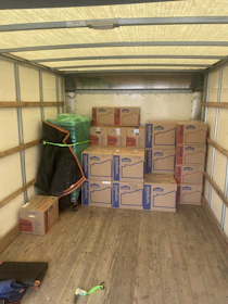 Team members carefully packing furniture inside a Maxitransporte van.