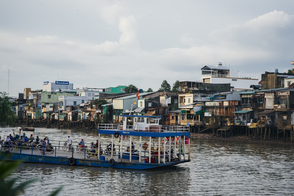 un barco azul y blanco que viaja por un río