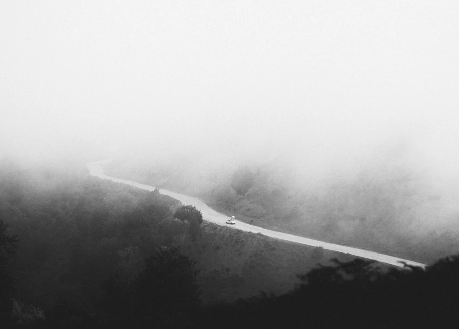 Quiet foggy road fading into the distance at dusk