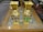 Two ornate golden vases with Egyptian motifs, including pharaoh heads and hieroglyphic designs, are placed on an intricate wooden table with geometric patterns. The vases have vibrant red, blue, and green ornamental detailing.