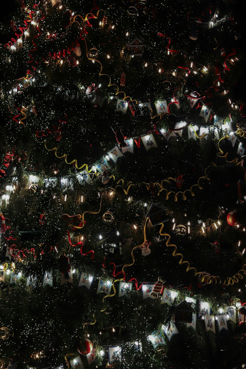 a large christmas tree is lit up at night