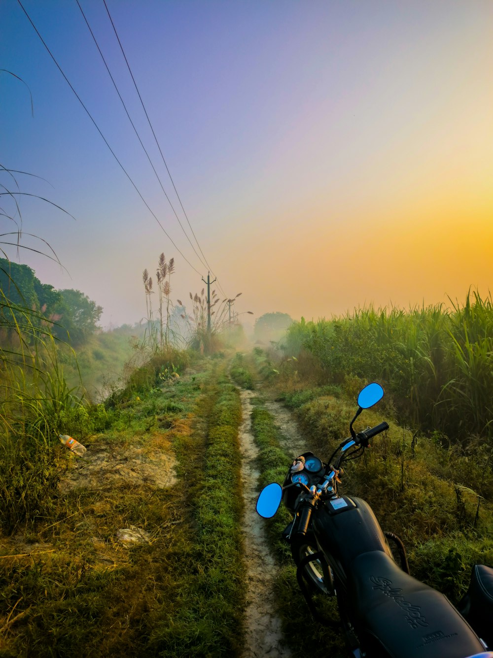 a motorcycle parked on the side of a dirt road