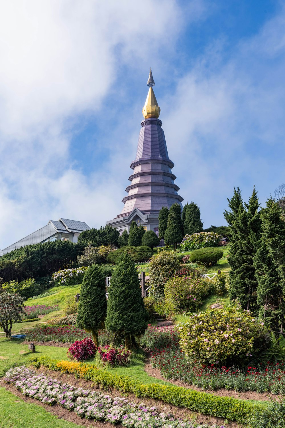 a very tall building sitting on top of a lush green hillside