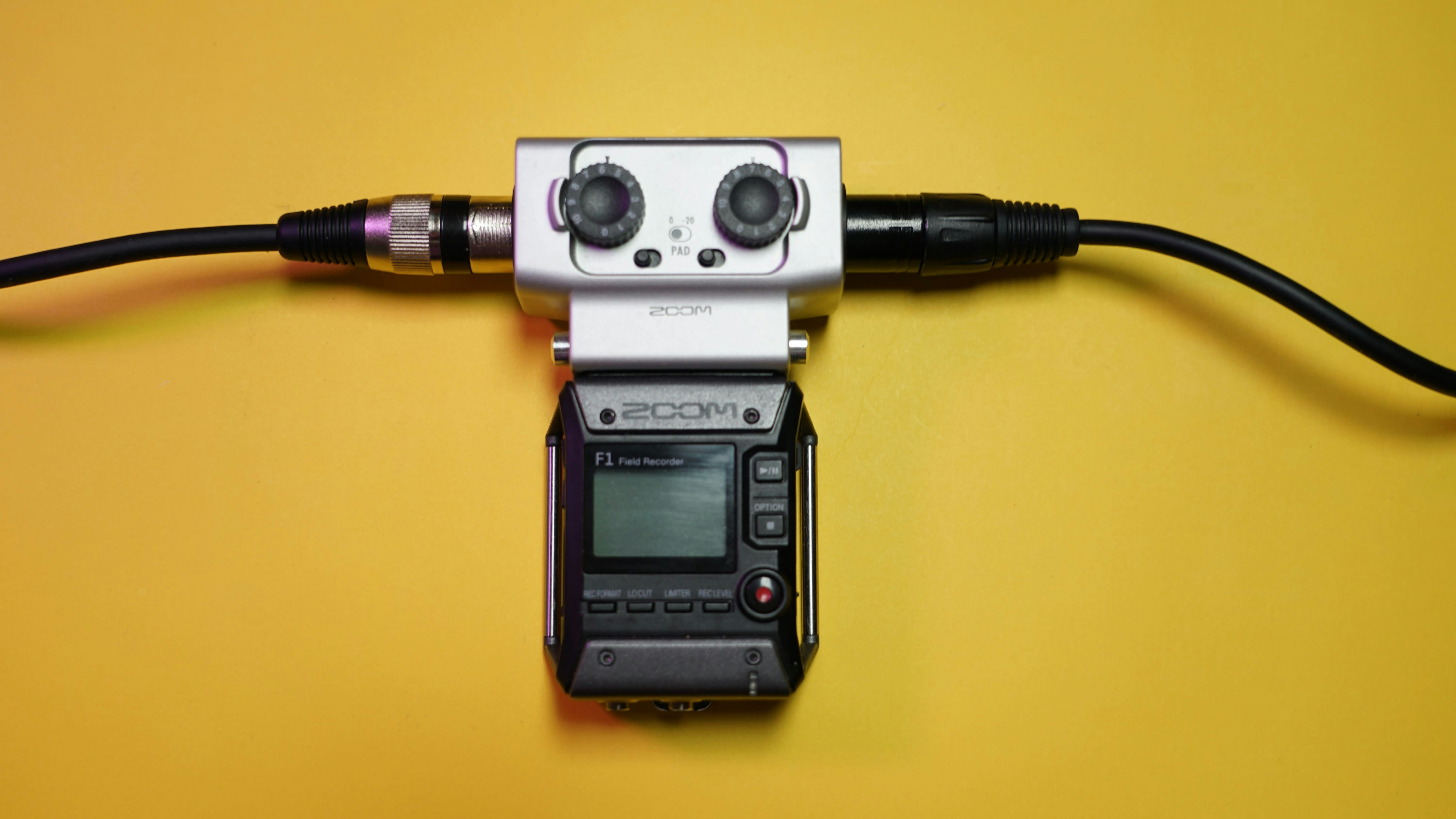 a camera attached to a cord on a yellow surface
