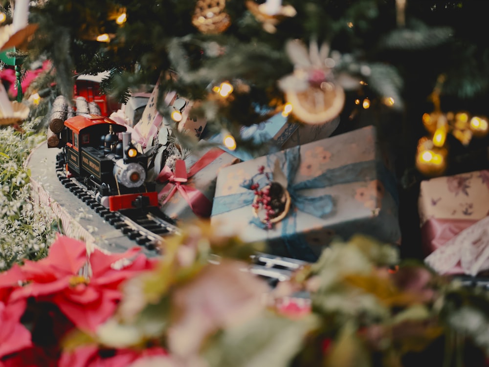 a toy train on a track near a christmas tree