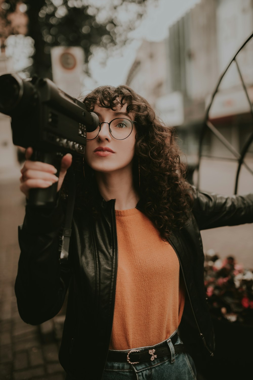 a woman holding a gun and wearing glasses