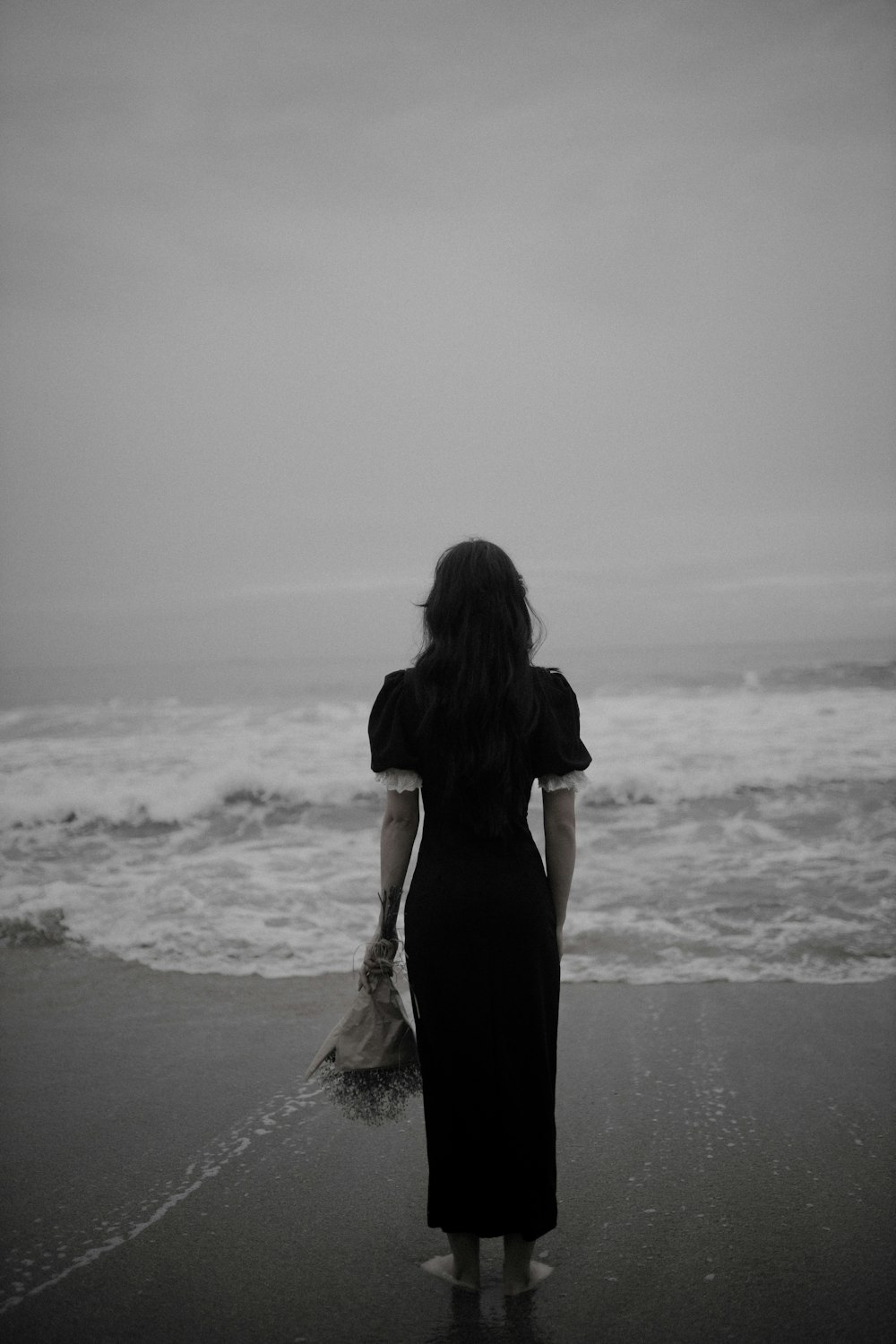 a woman standing on a beach next to the ocean