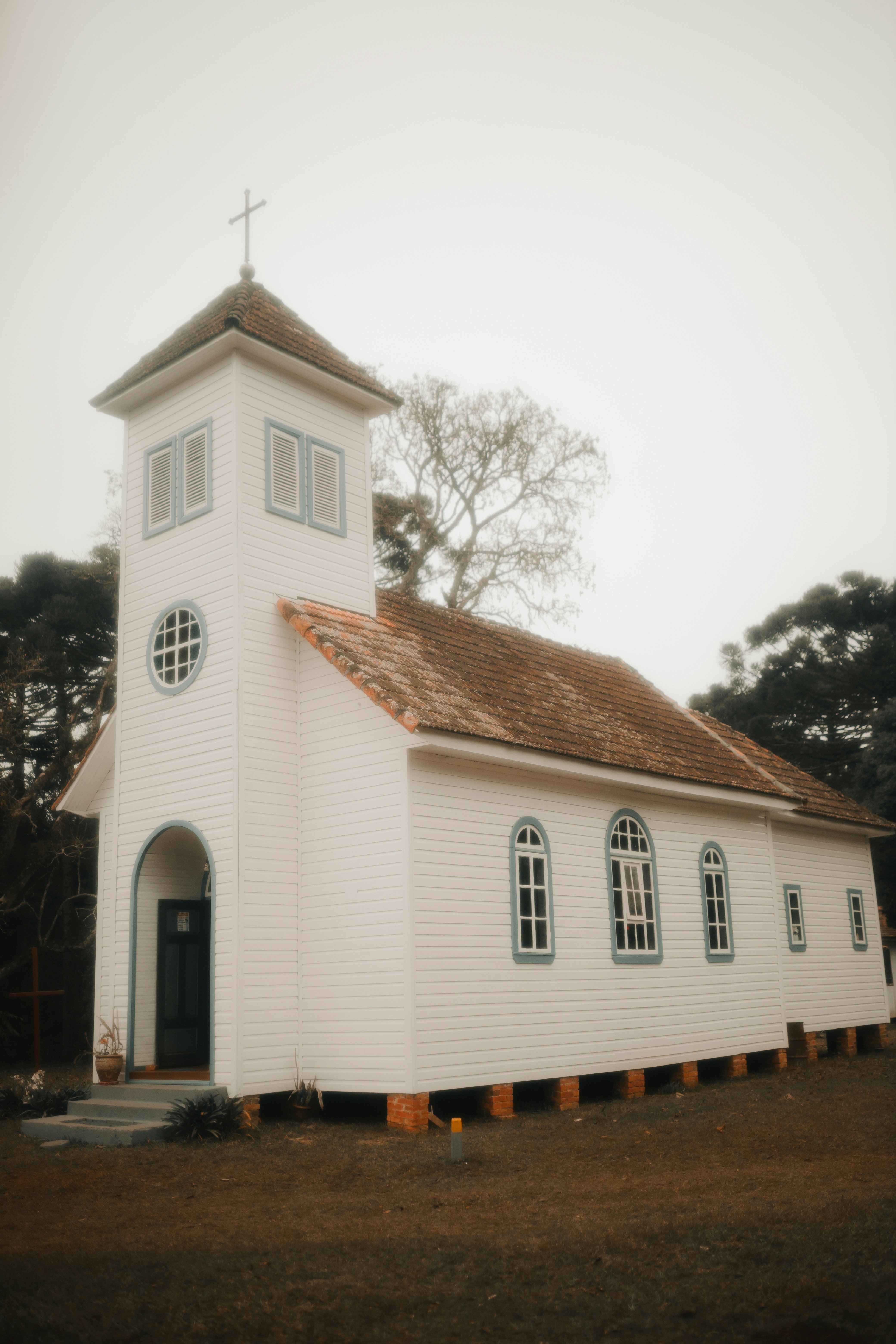 A white church with a cross on top of it photo – Free Grey Image on ...