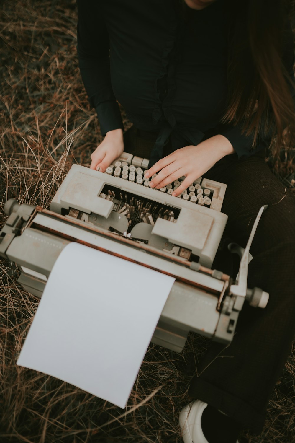 a woman is typing on an old typewriter