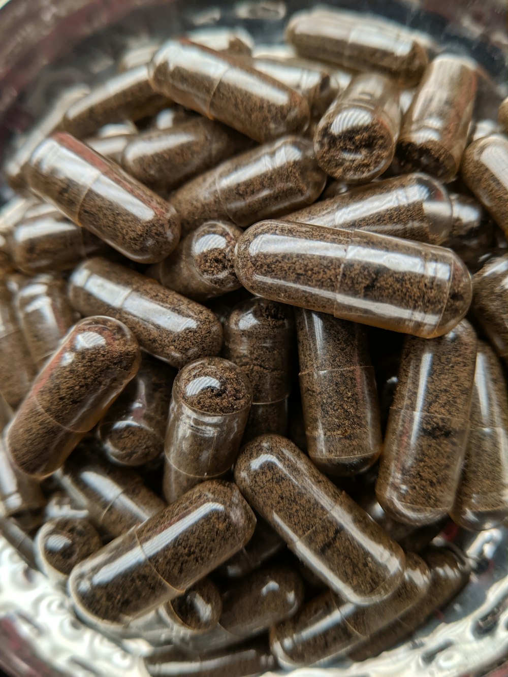 uma tigela cheia de muitas pílulas marrons
