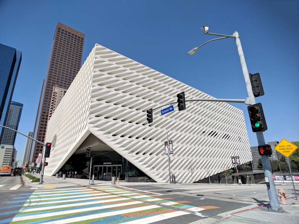 un grande edificio bianco con un lampione di fronte