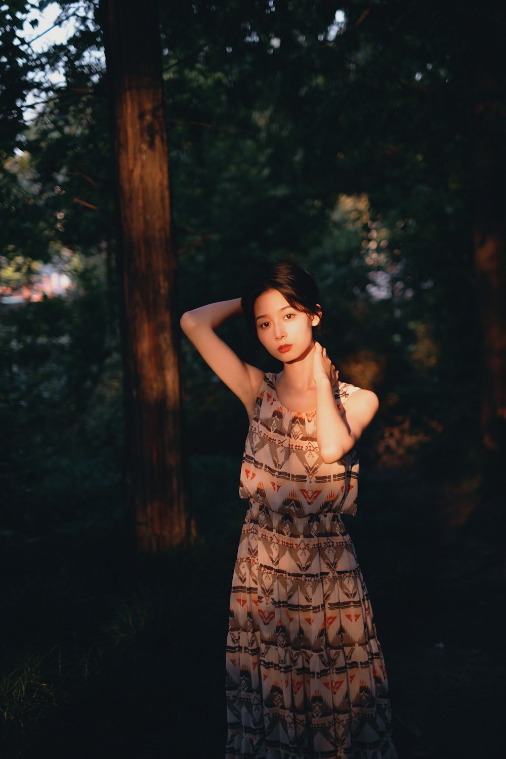 a woman in a dress standing in a forest