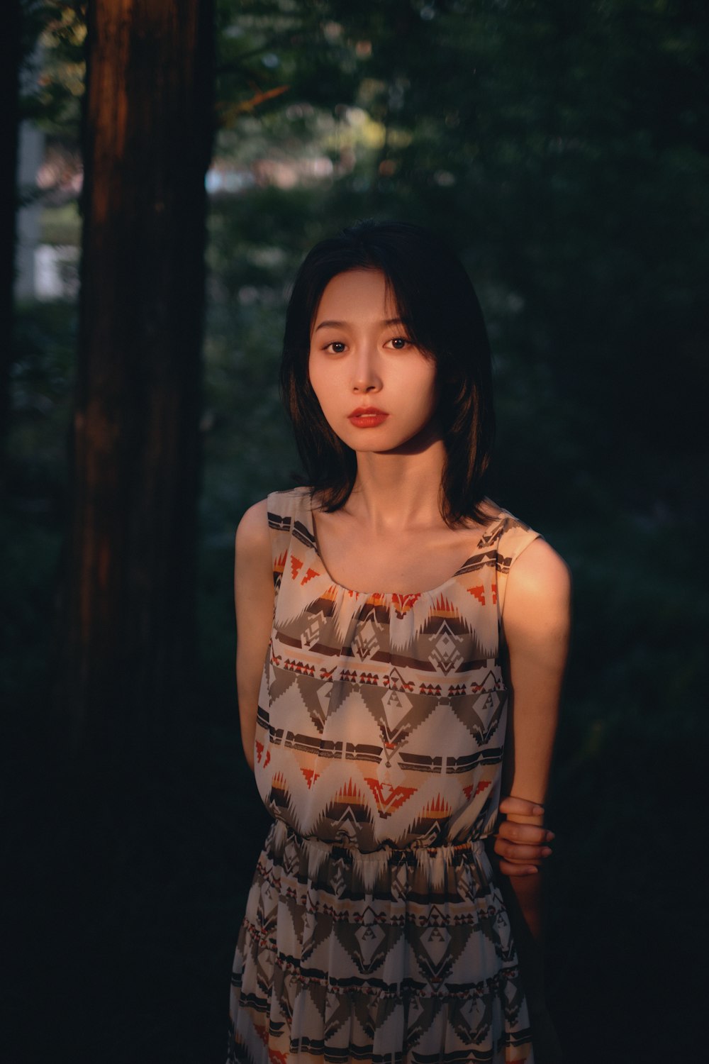 a woman standing in front of a tree