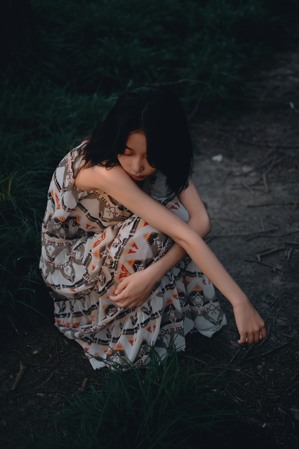 a woman in a dress sitting on the ground